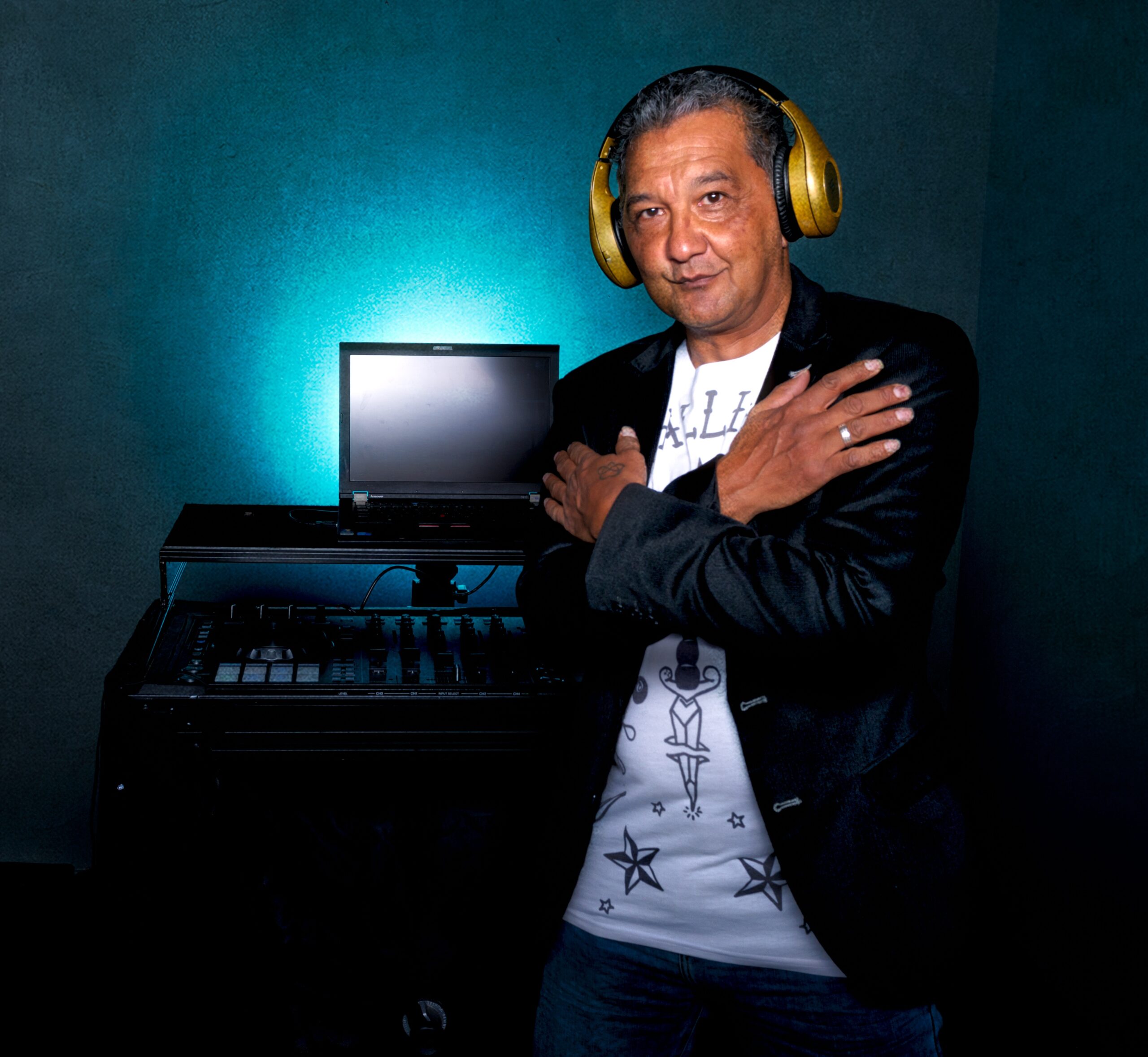 Roy Chamberlain (DJ FunKey R) poseert met koptelefoon voor zijn mobiele DJ-installatie en laptop.
