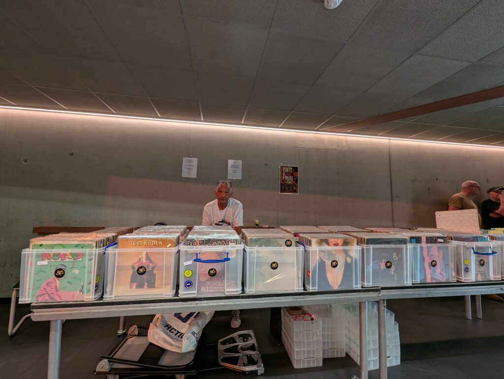 Roy Chamberlain van RC Records achter zijn stand tijdens de Platenbeurs Heerlen, met een ruime selectie vinylplaten voor verkoop.