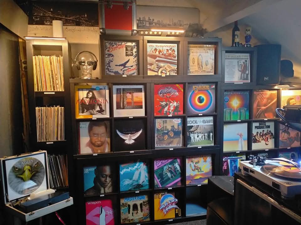 Overzicht van de vinylcollectie van RC Records met L-kasten, platenspeler en zorgvuldig opgebouwde muziekverzameling.